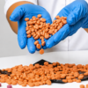 Several round orange botanical tablets arranged on a rustic wooden table surface